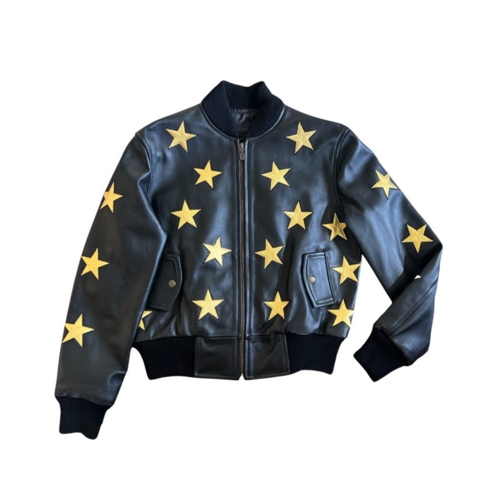 A woman wearing a black bomber jacket with metallic gold stars
