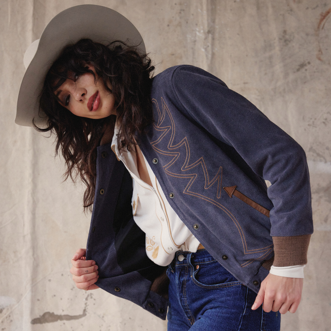 Woman wearing a denim bomber jacket that's embroidered