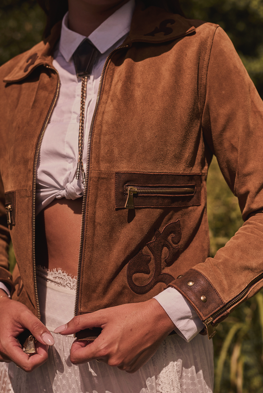 Woman wearing a brown embroidered jacket by Western & Co in outdoor setting 